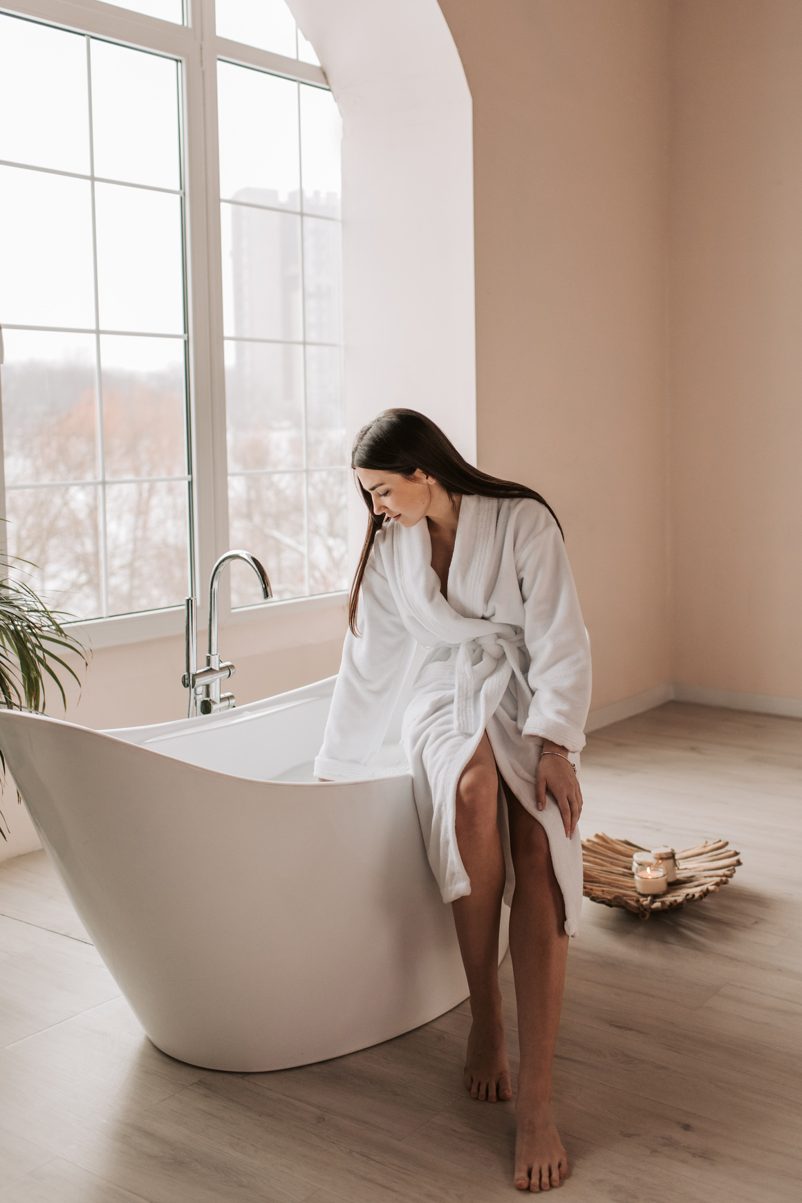 Woman in White Bathrobe Sitting on a Bathtub